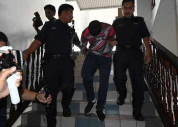 MOHAMAD Zulfikar Ishak diiringi anggota polis ketika dihadapkan ke Mahkamah Sesyen, Ayer Keroh, Melaka atas lima pertuduhan termasuk merogol remaja perempuan. - UTUSAN/MUHAMMAD SHAHIZAM TAZALI