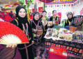 JUALAN KRAFTANGAN
PEMAIN alat muzik tradisional, Noor Aine Yusof (kiri) bersama empat usahawan ibu tunggal di bawah Jabatan Hal Ehwal Wanita Sabah, (dua dari kiri) Asmawati Anifiah, Rosemary Anne Tulat, Fatimah Tina dan Salume Masulim di gerai 
kraftangan.