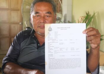 SAUDI Sidek menunjukkan salinan polis yang dibuat terhadap syarikat pengendali syarikat haji swasta di Kampung Bolok, Lanchang di Temerloh, Pahang.