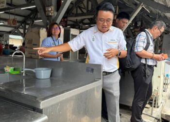 JOSEPH Ng Soon Siang (tengah) menunjukkan sinki keluli tahan karat yang dipasang bagi menggantikan sinki lama di Kompleks (Annex) atau Annex Pasar Air Itam di George Town, Pulau Pinang.