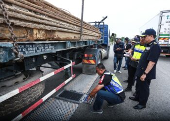 AZRIN Borhan (dua dari kanan) melihat anggotanya menimbang muatan sebuah lori yang membawa muatan besi di Plaza Tol Lebuhraya SKVE Saujana Putra, Kuala Langat, Selangor hari ini. UTUSAN/AFIQ RAZALI