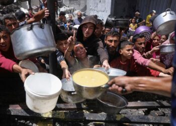 PENDUDUK Palestin berkumpul mendapatkan makanan yang dimasak di pusat pengedaran amal di Jabalia, utara Gaza. – AFP