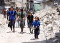 PENDUDUK Palestin berjalan sambil membawa periuk berisi makanan yang dimasak dari dapur amal di Jabalia, utara Gaza, kelmarin.- AFP