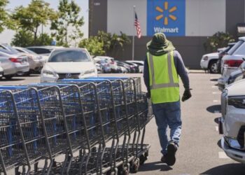 PETUGAS mengumpul troli di kawasan tempat letak kereta di pasaraya Wallmart di Burbank, California.-AGENSI