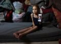 SEORANG kanak-kanak perempuan Palestin, Rahaf Ayyad, 12, yang mengalami malnutrisi menunjukkan gambar lamanya ketika sihat di Gaza City, Semenanjung Gaza. – AFP