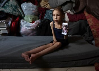 SEORANG kanak-kanak perempuan Palestin, Rahaf Ayyad, 12, yang mengalami malnutrisi menunjukkan gambar lamanya ketika sihat di Gaza City, Semenanjung Gaza. – AFP