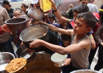 KANAK-KANAK Palestin beratur mendapatkan makanan yang disediakan badan amal di Gaza City. – AFP