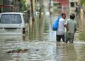PENDUDUK mengharungi jalan yang dinaiki air berikutan hujan lebat di Bengaluru, pada Isnin lepas.- AFP