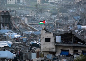 BENDERA Palestin 
berkibar di tengah runtuhan bangunan di Beit Lahia, utara Gaza.– AFP