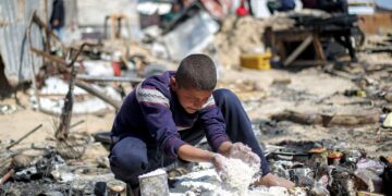 SEORANG remaja mengutip sisa tepung yang bertaburan di atas tanah selepas serangan Israel ke atas khemah pelarian di Khan Younis.-AFP