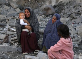 SEORANG wanita mendukung bayinya sambil menangis selepas melihat kesan kemusnahan akibat bedilan udara tentera Israel di Jabalia, tengah Semenanjung Gaza.  – AFP