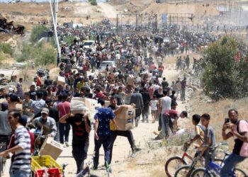 PENDUDUK Palestin membawa kotak berisi barangan asas yang diterima di tengah Semenanjung Gaza. – AFP