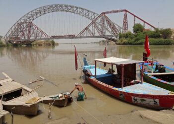 SEORANG lelaki membetulkan botnya di Sungai Indus di Sukkur, wilayah Sind, Pakistan. – AFP