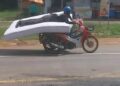 TANGKAP layar video menunjukkan seorang lelaki menunggang motosikal sambil meniarap atas tilam di Thailand. – AGENSI