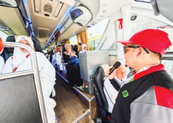 MOHD. Azir Shahril (kanan) memberi penerangan kepada jemaah sebelum mereka turun dari bas di hentian As Sahel, Wadi Starah dalam perjalanan dari Madinah ke Mekah.