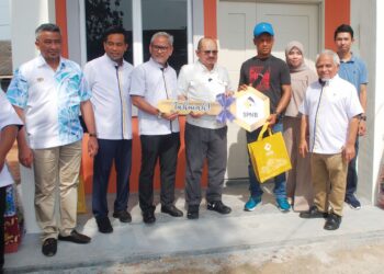 SHAMSUL Iskandar Mohd. Akin menyampaikan replika kunci Rumah Mesra Rakyat kepada Mohd. Amir Othman  di Taman Desa Molek, Ayer Molek, Melaka semalam-UTUSAN/AMRAN MULUP