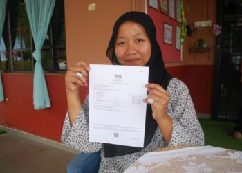 EVY Mariska Ulandari Sukarmah menunjukkan keputusan 8A SPM di Rumah Kasih Tun Abdul Aziz, Durian Daun, Melaka, semalam. - UTUSAN/AMRAN MULUP