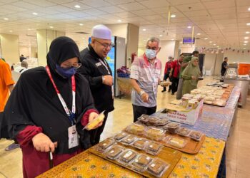 MUHAMMAD NAJIB Zulkifli (dua dari kiri)  melayan pelanggan di kafeteria Hotel Land Premium, Mekah baru-baru ini.