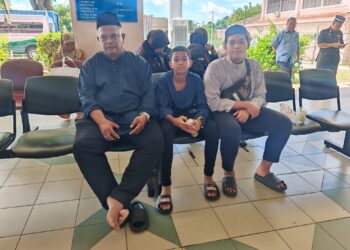 MOHD. Izham Rosly bersama dua anak lelakinya menunggu urusan bedah siasat di Jabatan Perubatan Forensik, Hospital Melaka, semalam.