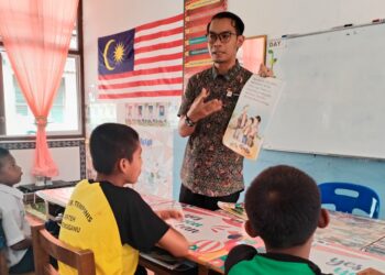 KHAIRUL Azmi Ab. Rahman bersama murid-murid kelas Program Pendidikan Khas Integrasi (PPKI) di SK Tempinis, Besut, Terengganu. 
– UTUSAN / WAN ZURATIKAH IFFAH WAN ZULKIFLI