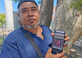 RAHIM Rahman menunjukkan gambar kenangan bersama Farra Adrienna ketika ditemui di Jabatan Perubatan Forensik Hospital Melaka. UTUSAN/AMRAN ALI