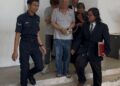 SUSPEK (dua dari kanan) dibawa keluar dari Kompleks Mahkamah Kangar selepas permohonan reman berhubung kes khianat merosakkan palang parkir pintar di Jalan Seruling, Kangar, Perlis. -UTUSAN/ASYRAF MUHAMMAD