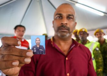 S. AHRENTHEREN menunjukkan gambar  mendiang abangnya Sarjan S. Perumal yang maut dalam kemalangan dengan lori di Jalan Sungai Manik-Sungai Lampam di Teluk Intan, Perak hari inii. - UTUSAN/MUHAMAD NAZREEN SYAH MUSTHAFA