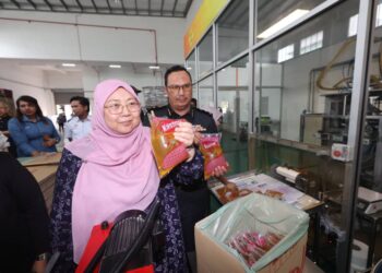 FUZIAH Salleh menunjukkan minyak paket dibungkus oleh sebuah syarikat di Jalan Kempas Lama, Johor Bahru.