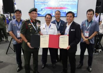 MUSTAPHA Sakmud (tengah) menyaksikan pertukaran dokumen antara Arman Rumaizi Ahmad (dua dari kiri) dan Shamsuri Arif di Pavilion KPT sempena LIMA’25 di MIEC, Langkawi.
