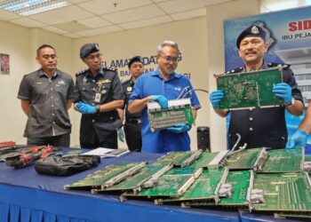 MOHAMAD Rusli Mat (kanan) menunjukkan kad akses TM serta peralatan yang dirampas daripada suspek dalam sidang akhbar di IPD Jasin, Melaka, hari ini.-UTUSAN/AMRAN ALI