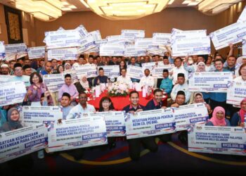 STEVEN Sim Chee Keong bersama penerima bantuan pada Majlis Penyerahan Bantuan PHEKS Peringkat Zon Tengah di Klang, Selangor. - UTUSAN/AFIQ RAZALI