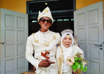 MOHD. Shaiful Nizam Yeop Mat Isa dan Rapeah Sani melangsungkan persandingan perkahwinan mereka pada Majlis Kenduri Perkahwinan Beramai-ramai melibatkan 25 pasangan di Lenggong, Perak hari ini. - UTUSAN/FADZIL ZAINOL