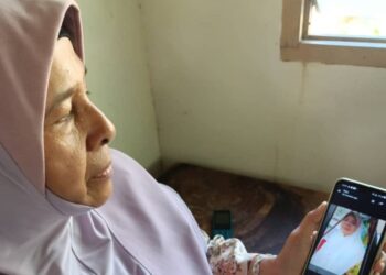SITI Safur Abdullah menunjukkan gambar kakaknya, Habsah @ Salimah ketika ditemui di rumahnya di Jalan Weng-Baling, di sini.