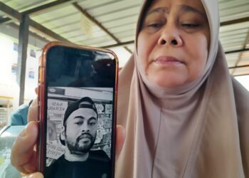 FATIMAH Abdullah menunjukkan gambar Mohd. Azli Elias yang maut akibat terlanggar lembu ketika ditemui di Unit Forensik Hospital Kota Tinggi, Johor hari ini.