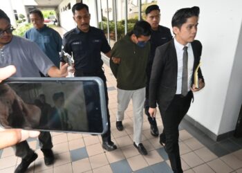 MUHAMMAD Aiezad Asni (baju hijau) diiringi anggota polis ketika dihadapkan ke Mahkamah Sesyen, Ayer Keroh, Melaka kerana mencabul seorang pelajar lelaki. - UTUSAN/MUHAMMAD SHAHIZAM TAZALI