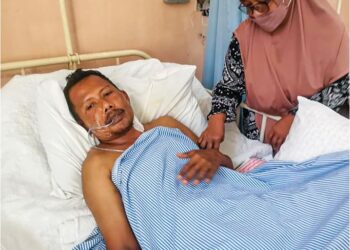 KOPERAL Haslizal Mohd Ali dijaga ibunya, Hamidah Abdullah 
di Hospital Teluk Intan. – UTUSAN/AIN SAFRE BIDIN