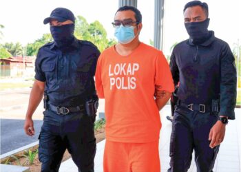 ASROLFANDI Ab. Suki (tengah) diiringi anggota polis semasa menghadiri prosiding perbicaraan di Mahkamah Sesyen Pasir Mas, Kelantan, semalam – UTUSAN/KAMARUL BISMI KAMARUZAMAN