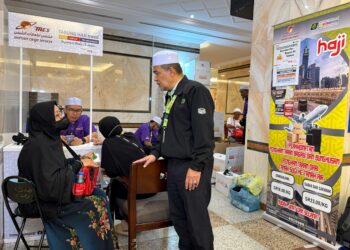 MOHAMAD ZAMRY (kanan) ketika menjawab soalan seorang jemaah wanita di Abraj Al Janadriyah, Mekah baru-baru ini.