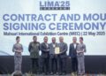 MOHAMED Khaled Nordin (tengah) menyaksikan pertukaran MoU antara Ketua Setiausaha Kementerian Pertahanan, Datuk Lokman Hakim Ali dan Ketua Pegawai Eksekutif Boustech, Sharifuddin Md. Zaini Al-Manaf mengenai kerjasama strategik program komunikasi ATM di Langkawi semalam. – UTUSAN/FARIZ RUSADIO