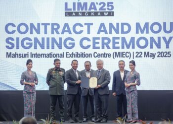 MOHAMED Khaled Nordin (tengah) menyaksikan pertukaran MoU antara Ketua Setiausaha Kementerian Pertahanan, Datuk Lokman Hakim Ali dan Ketua Pegawai Eksekutif Boustech, Sharifuddin Md. Zaini Al-Manaf mengenai kerjasama strategik program komunikasi ATM di Langkawi semalam. – UTUSAN/FARIZ RUSADIO