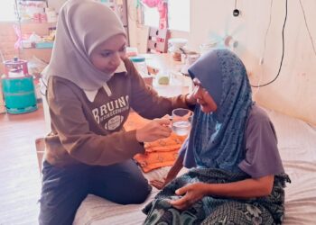 NOR Ain Natasha Maae (kiri) membantu menguruskan Rosila Noor di Kampung Lubuk Lesung, Kijal, Kemaman, Terengganu. –  UTUSAN/NIK NUR IZZATUL HAZWANI NIK ADNAN
