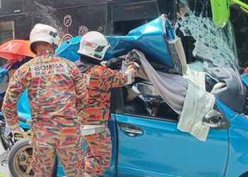 ANGGOTA bomba berusaha mengeluarkan mayat mangsa yang tersepit dalam kemalangan di Kampung Sungai Sam, Kuala Krai, Kelantan.-IHSAN BOMBA