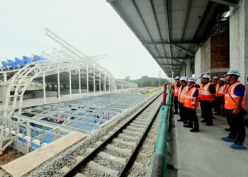 DARWIS Abd. Rahman (depan) meninjau landasan ECRL di stesen Kota SAS di Kuantan, Pahang. - FOTO/SHAIKH AHMAD RAZIF