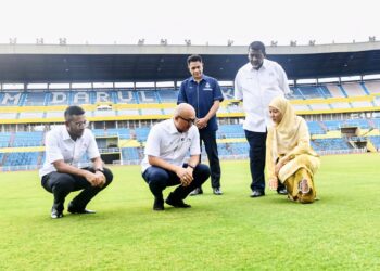 FADZLI Mohamad Kamal (duduk, tengah) melihat rumput padang Stadium Darul Makmur di Kuantan, Pahang yang mendapat pengiktirafan Persekutuan Bola Sepak Antarabangsa (FIFA) sebagai padang rumput asli pertama di Asia.