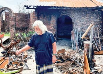 MOHAMAD NASIR Abdul Hamid menunjukkan serpihan besi-besi basikal dan motosikal yang hangus dalam kejadian letupan paip gas di Kampung Kuala Sungai Baru, Subang Jaya, semalam. – UTUSAN/NUR ATHIRAH HAYADI