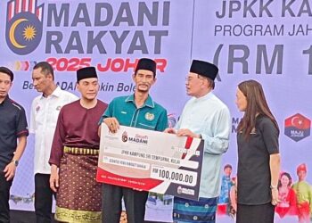ANWAR Ibrahim menyampaikan geran kepada wakil Jawatankuasa Pembangunan dan Keselamatan Kampung (JPKK) Kampung Sri Sempurna, Kulai pada Program Madani Rakyat 2025 di pusat beli-belah Toppen, Johor Bahru. - UTUSAN/BAAZLAN IBRAHIM