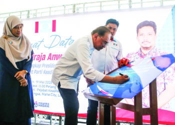 Anwar Ibrahim menandatangani plak  ketika merasmikan Pejabat Parti Keadilan Rakyat, (KEADILAN) Langkawi di Kuah, semalam. - UTUSAN/ SHAHIR NOORDIN