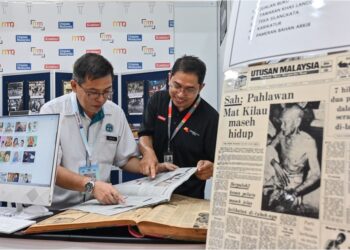 MOHAMMMAD Fahmi Asraf Khan (kanan) menunjukkan laporan akhbar di bawah Media Mulia kepada  pengunjung di PBAKL 2025 di Kuala Lumpur,  semalam.