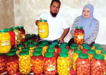 MOHD. Zulhilmi Ahmad dan Tengku Norhidayu Tengku Nazri menunjukkan jeruk buah-buahan dihasilkan mereka di Kampung Kubang Palas, Hulu Terengganu. – UTUSAN/NOOR HAYATI MAMAT