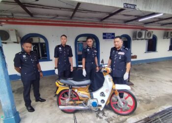 AZAMUDDIN Ahmad @ Abu (kanan) menunjukkan motosikal suspek kes samun yang dirampas di Ibu pejabat Polis Daerah Besut di Besut, Terengganu. - UTUSAN / WAN ZURATIKAH IFFAH WAN ZULKIFLI
